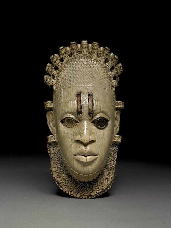A carved ivory hip pendant in the form of a mask. The kingdom of Benin (13-19th century CE) in West Africa (modern southern Nigeria). With bronze and iron inlays. Possibly depicting Queen Idia. Benin City, 16th century CE. Height: 24.5 cm. (British Museum, London)